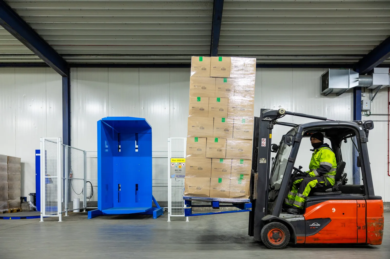 Un carrello elevatore porta un pallet carico al ribaltatore di pallet PalletRotator K11