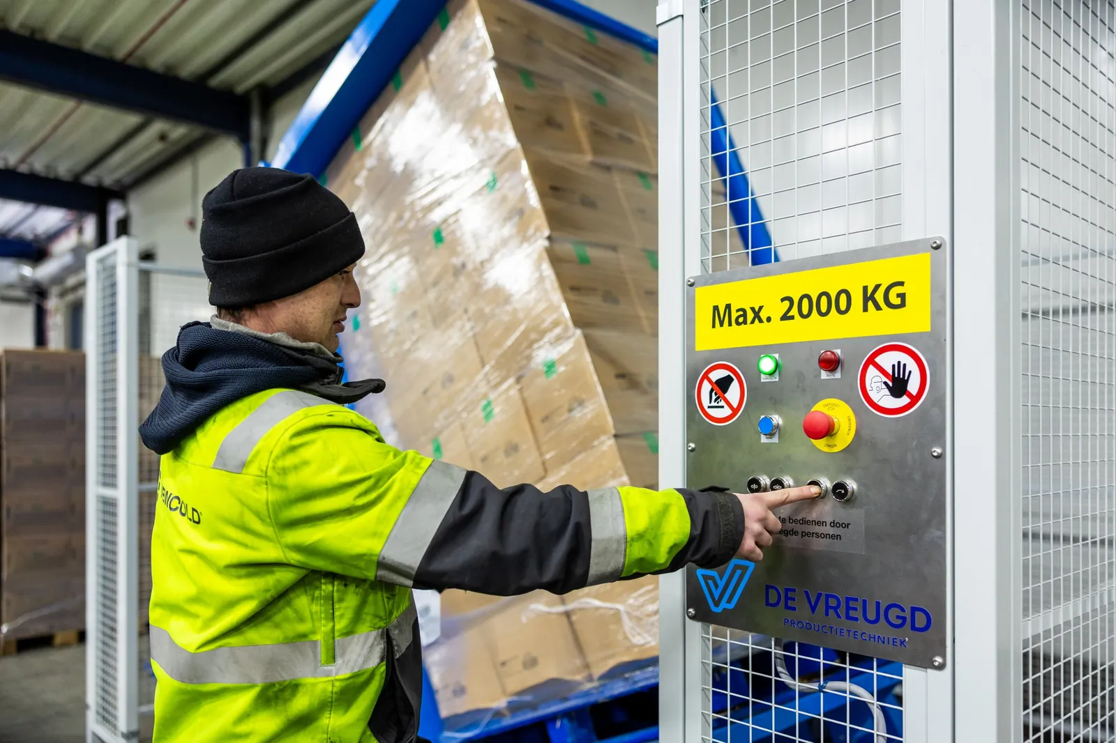 Un operatore usa il ribaltatore di pallet PalletRotator K11 mentre il pallet si ribalta